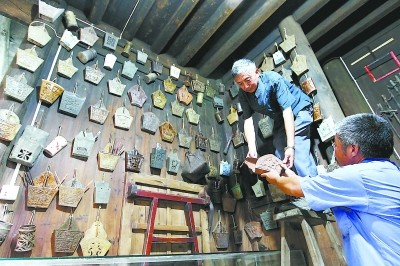 展牆上掛滿了不同年代、不同材質制成的“筷子籠”。