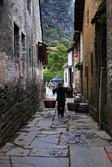 行走在小巷中的挑夫