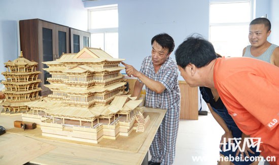 姚春生正在展示自己的作品。古冶區委宣傳部/供圖