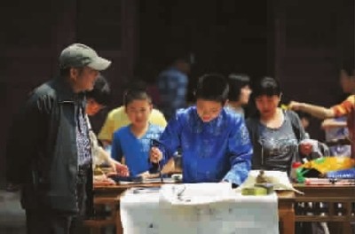 游客饒有興趣地觀看孩子練書法