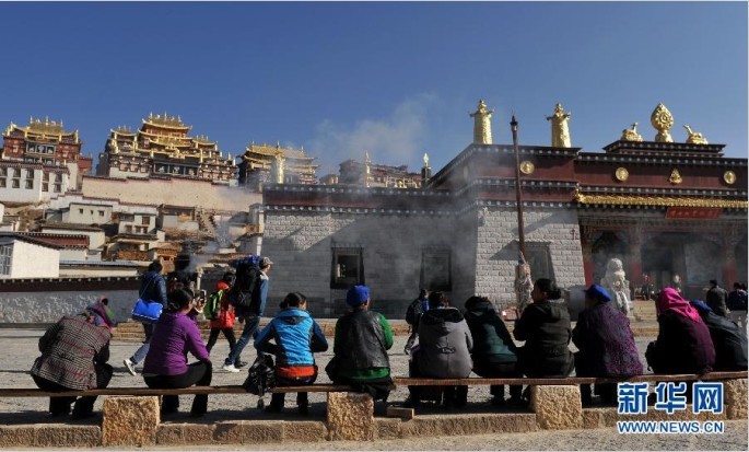 在雲南香格裡拉縣的噶丹松贊林寺外，一些游客坐在椅子上休息