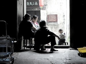 窄窄石板巷旁，高牆下一扇門，門檐下掛著一對紅燈籠，厚重木門後，就是一個高樓高牆包圍的小小庭院，曾凡聰一家人在這裡住了二十多年