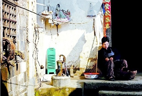 村民在老屋前做著家務
