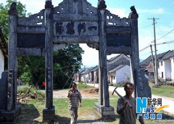 在廣西恭城瑤族自治縣西嶺鄉楊溪村楊溪古村，兩位村民從古村一座牌坊下經過