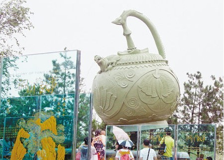 游客們在銅川園裡觀賞巨大的倒流壺