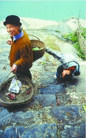 2003年的大昌古城，一位老人和孩子在南門外的石階上游戲