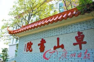 創建人林德泉手書的“卓山書院”石匾背後是即將竣工的卓山中學新文體中心