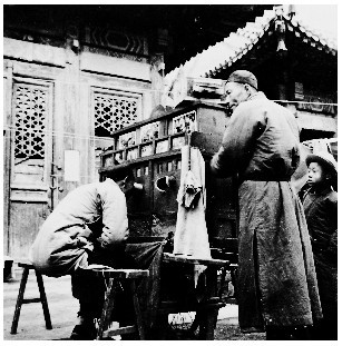 隆福寺廟會上游人在看拉洋片
