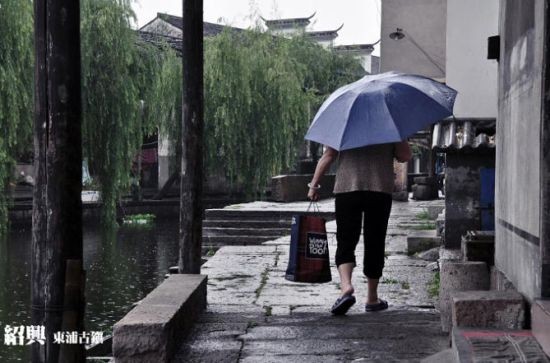阿婆撐著傘，緩緩走過